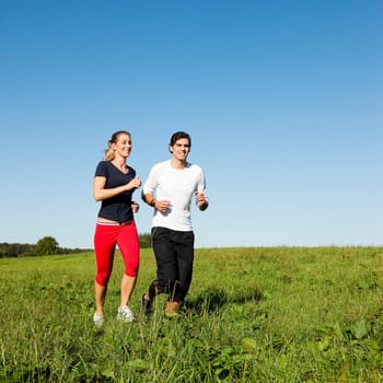 Sports couple jogging in summer