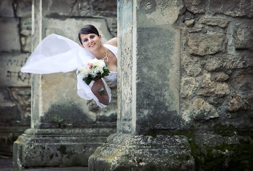 Bride  posing against old wall