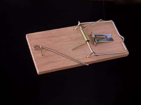 Mouse trap on a plain black background
