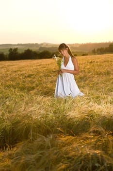 Romantic woman in sunset corn field wear dress