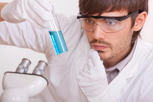 researcher with blue liquid flask