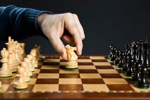 Hand moving knight on chess board