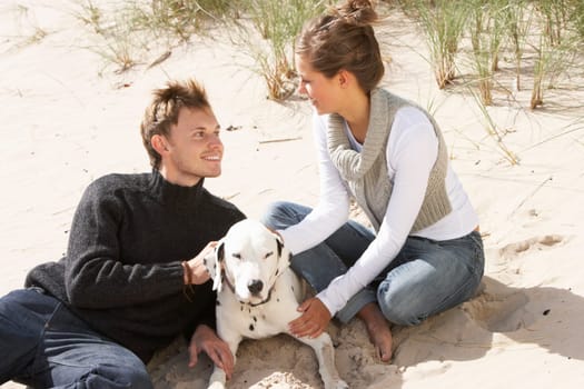 Portrait Of Romantic Teenage Couple On Beach With Dog
