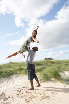 Energetic Young Couple Having Fun In Dunes By Beach