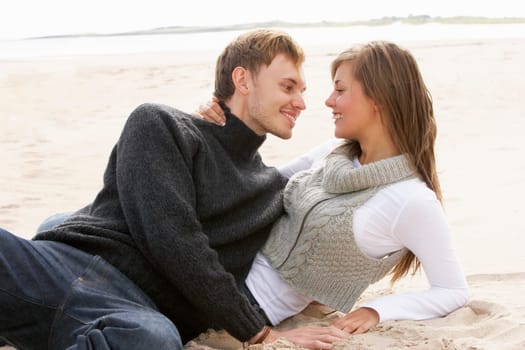 Young Romantic Couple Relaxing On Beach Together