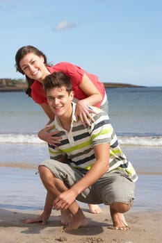 Affectionate Teenage Couple Having Fun On Beach