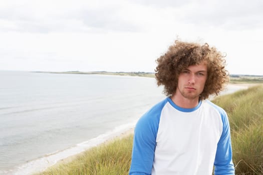 Young Man Standing In Sand Dunes