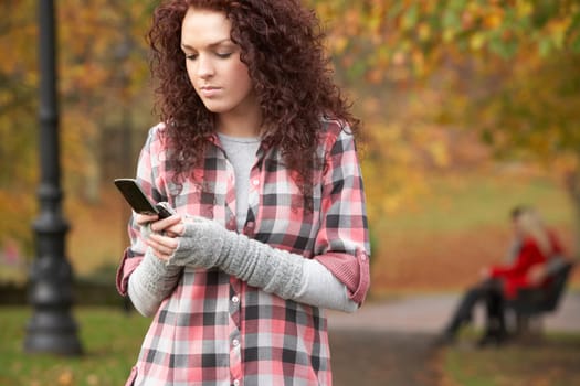Frustrated Teenage Girl Making Mobile Phone Call In Autumn Landscape