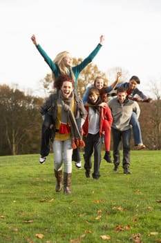 Group Of Teenage Friends Having Piggyback Rides In Autumn Landscape