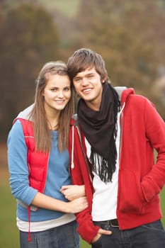 Romantic Teenage Couple Walking Through Autumn Landscape