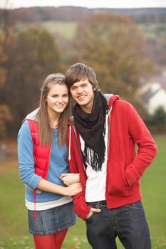 Romantic Teenage Couple Walking Through Autumn Landscape
