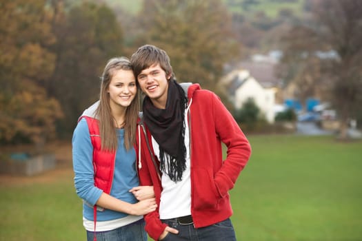 Romantic Teenage Couple Walking Through Autumn Landscape