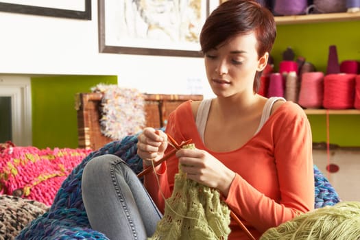 Young Woman Sitting In Chair Knitting