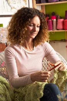 Woman Sitting In Chair Knitting