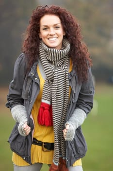 Smiling Teenage Girl Standing In Autumn Landscape