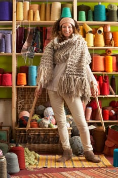 Woman Wearing Knitted Scarf Standing In Front Of Yarn Display