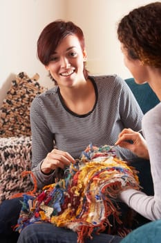 Two Women Knitting Together At Home
