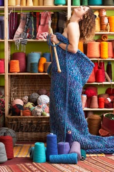 Naked Woman Standing In Knitted Item Standing In Front Of Yarn Display