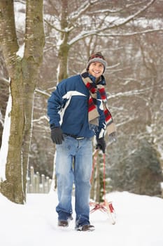 Man Pulling Sledge Through Winter Landscape