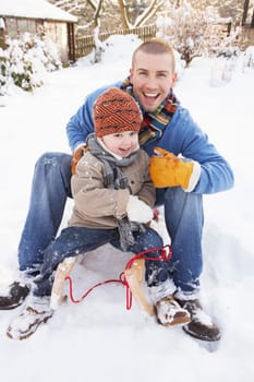 Father And Son Sitting On Sledge