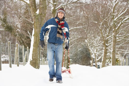 Man Pulling Sledge Through Winter Landscape