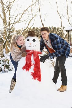 Teenage Couple Building Snowman