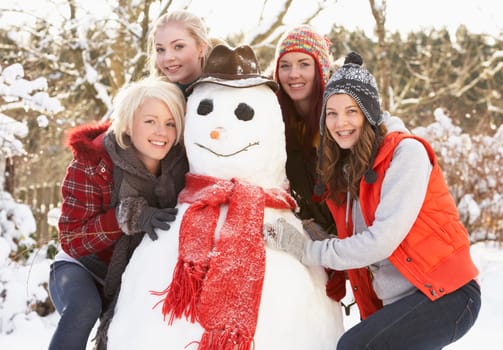Group Of Teenage Girls Building Snowman
