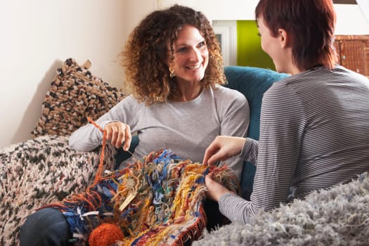 Two Women Knitting Together At Home