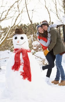 Teenage Couple Building Snowman