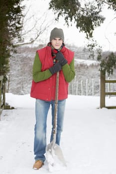 Young Man Clearing Snow From Drive
