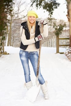 Teenage Girl Clearing Snow From Drive