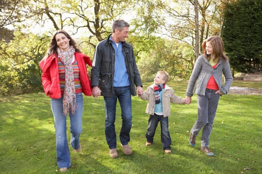 Young Family Outdoors Walking Through Park