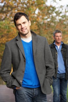 Two Men Standing Outside In Autumn Woodland