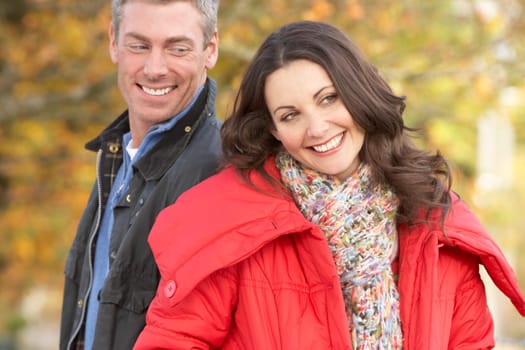 Young Couple Walking Through Autumn Park