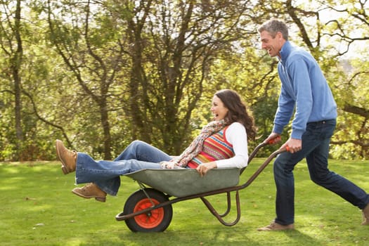 Couple With Man Giving Woman Ride In Wheelbarrow