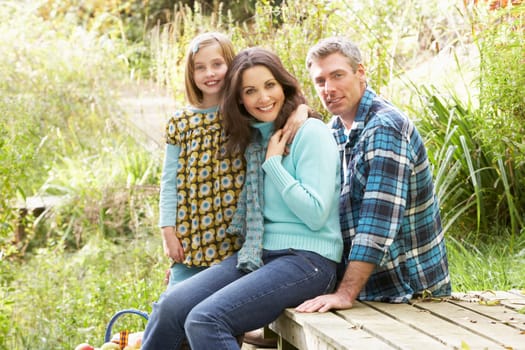 Parents And Daughter Having Picnic In Countryside