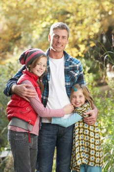 Father And Children Standing Outdoors On Wooden Walkway In Autumn Landscape