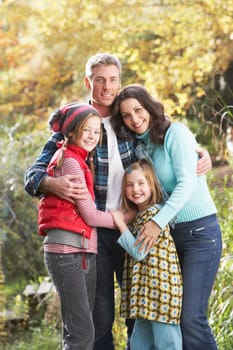 Family Group Standing Outdoors On Wooden Walkway In Autumn Landscape