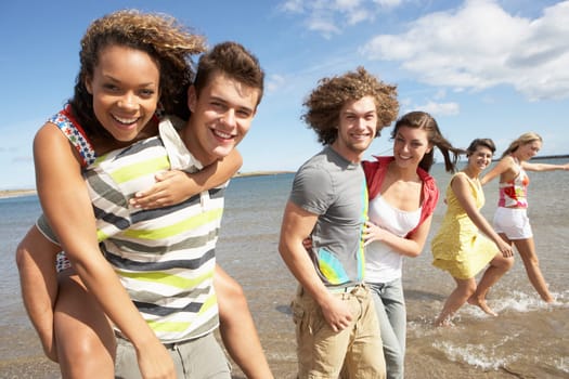 Group Of Young Friends Walking Along Summer Shoreline