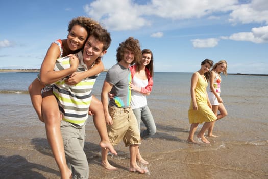 Group Of Young Friends Walking Along Summer Shoreline