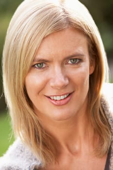 Close Up Portrait Of Smiling Blonde Woman Outdoors