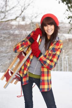 Woman Holding Sledge In Snowy Landscape
