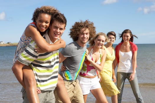 Group Of Young Friends Walking Along Summer Shoreline