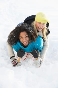 Couple Sledging Through Snowy Woodland