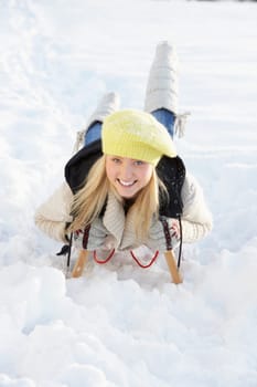 Teenage Girl Riding On Sledge In Snowy Landscape
