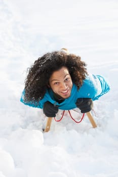 Young Man Riding On Sledge In Snowy Landscape