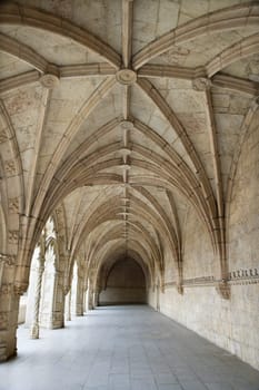 Arched exterior hallway of the Monastery of Jeronimos in Lisbon, Portugal. Vertical shot.