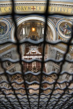 Altar in St Peter's Basilica seen through fencing. Vertical shot.