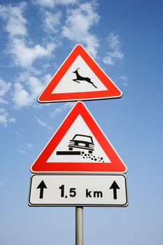 Rural road signs and blue sky in Europe. Vertical shot.