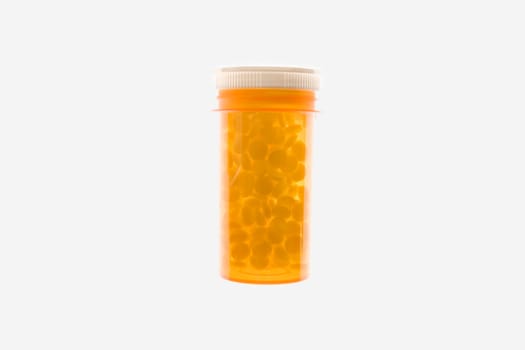 Yellow plastic medicine bottle filled with pills. Horizontal shot. Isolated on white.
